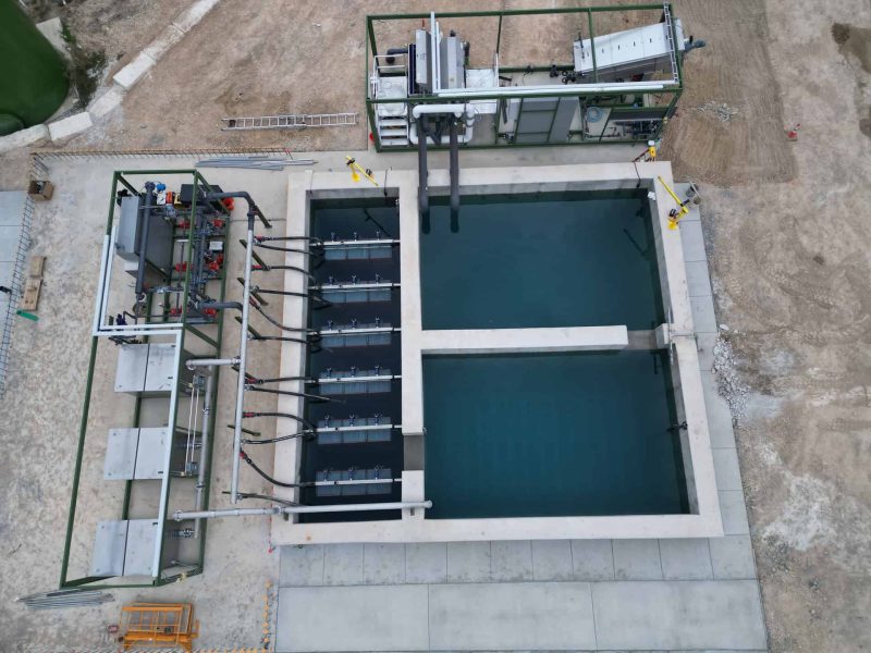 Industrial water treatment system with clarification tanks and filtration units at a construction site.
